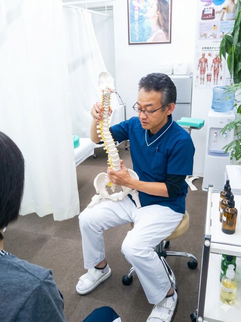 えんどう整骨院の院長が脊椎模型でヘルニアを説明している様子